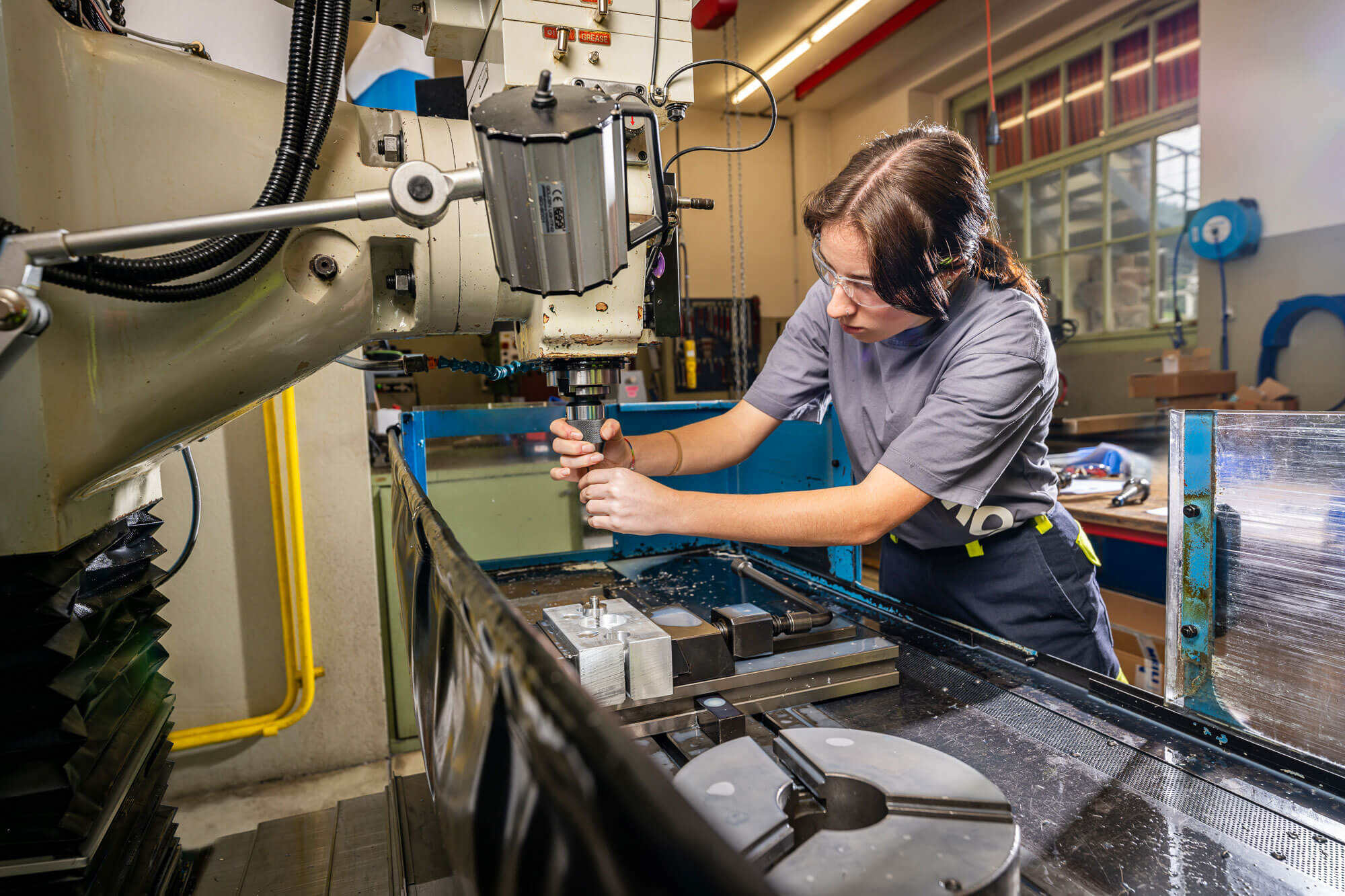 Lernende Polymechanikerin bei der Arbeit mit modernsten Maschinen